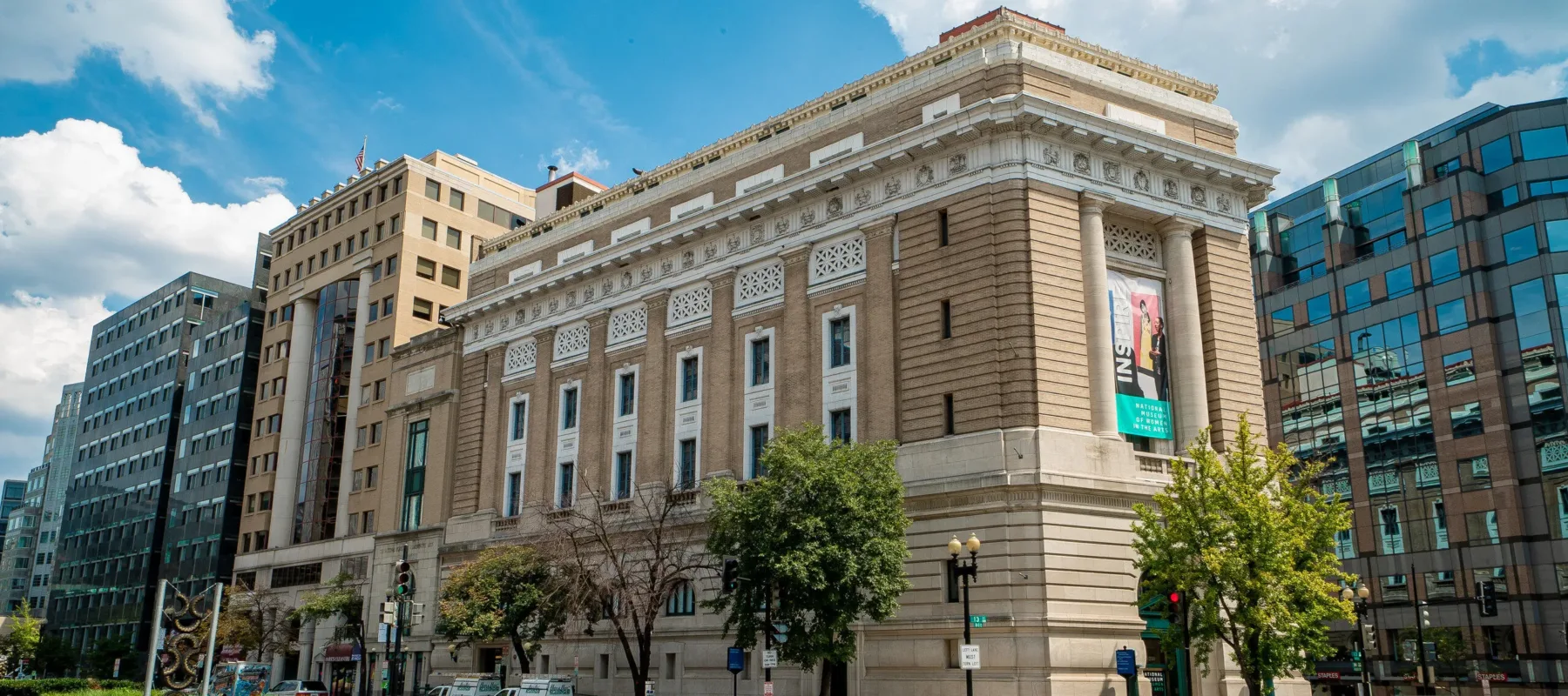 Exterior color photo of the museum building with a blue sky and clouds.