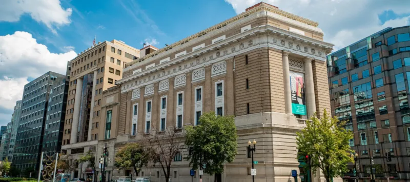 Exterior color photo of the museum building with a blue sky and clouds.