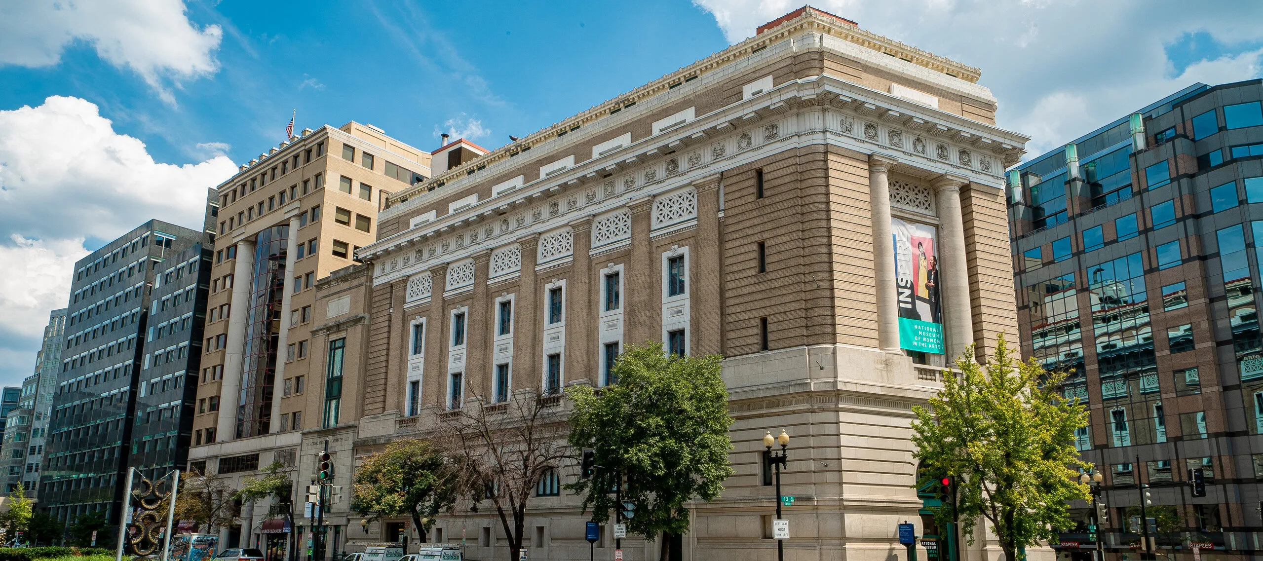 Exterior color photo of the museum building with a blue sky and clouds.