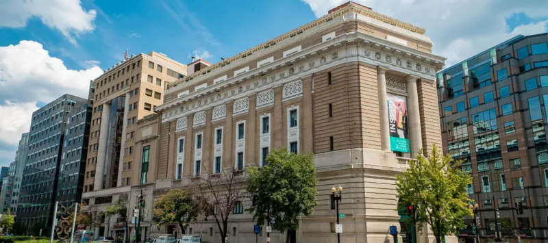 Exterior color photo of the museum building with a blue sky and clouds.