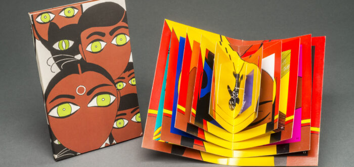 A brightly colored book displayed open whose pages decrease in size toward the center. To the left, a vertical rectangle on which is depicted five stylized faces with black hair, medium-dark skintone,  green eyes, and no mouths. A black cat with green eyes is also among the faces.
