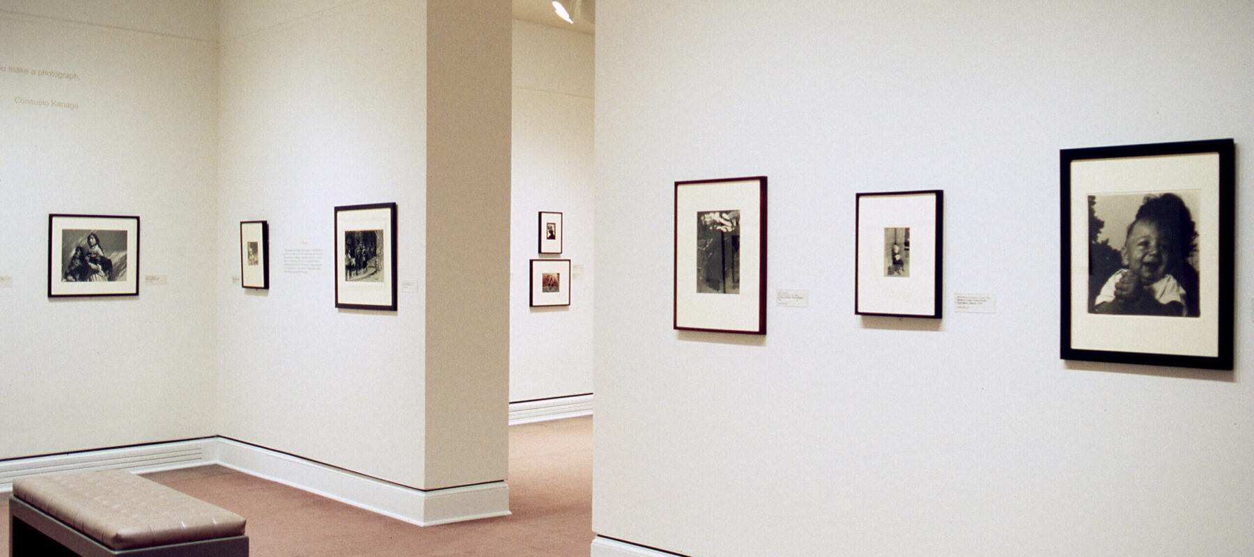 Several black and white photographs hanging on a white gallery wall.