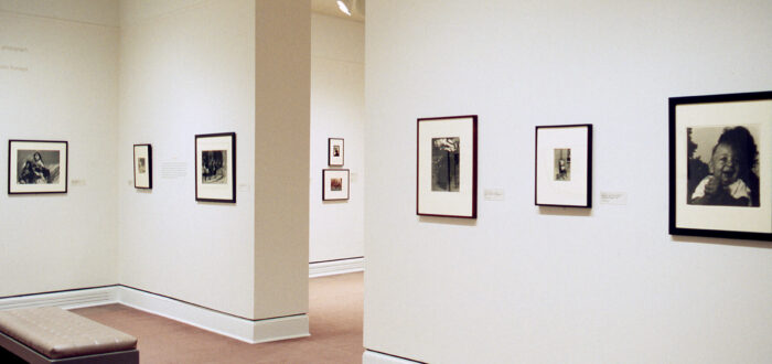 Several black and white photographs hanging on a white gallery wall.