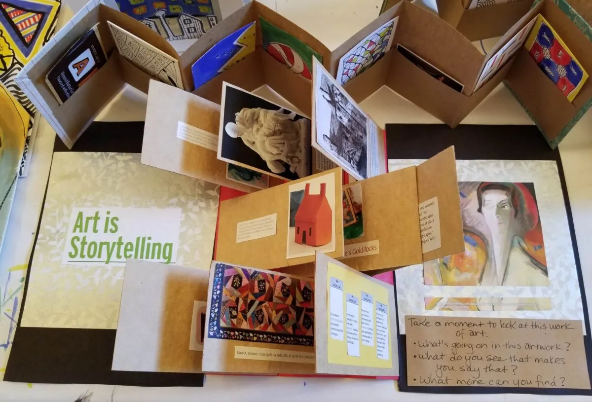 A birds-eyed view of a variety of artists books showing a variety of folded paper and works of art.