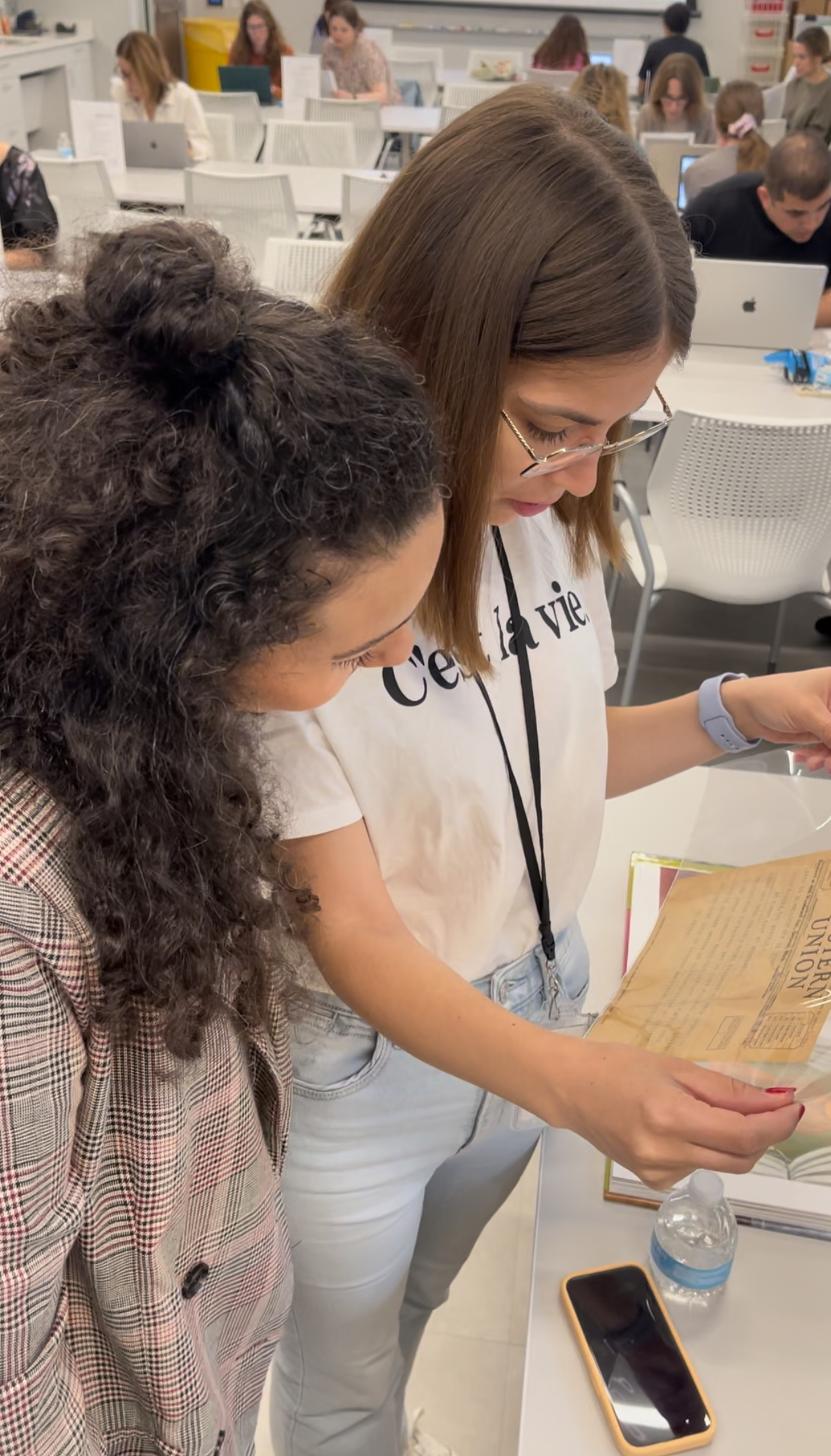 Participants examine a historical letter in a protective sleeve.