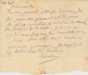 A handwritten letter by Frida Kahlo in Spanish on a piece of tan colored paper that is torn in half.