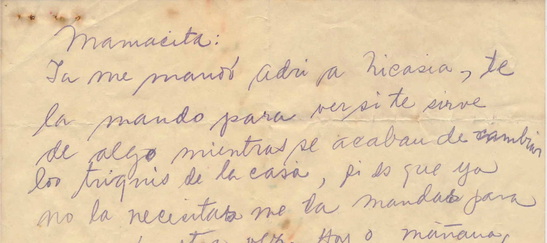 A handwritten letter by Frida Kahlo in Spanish on a piece of tan colored paper that is torn in half.