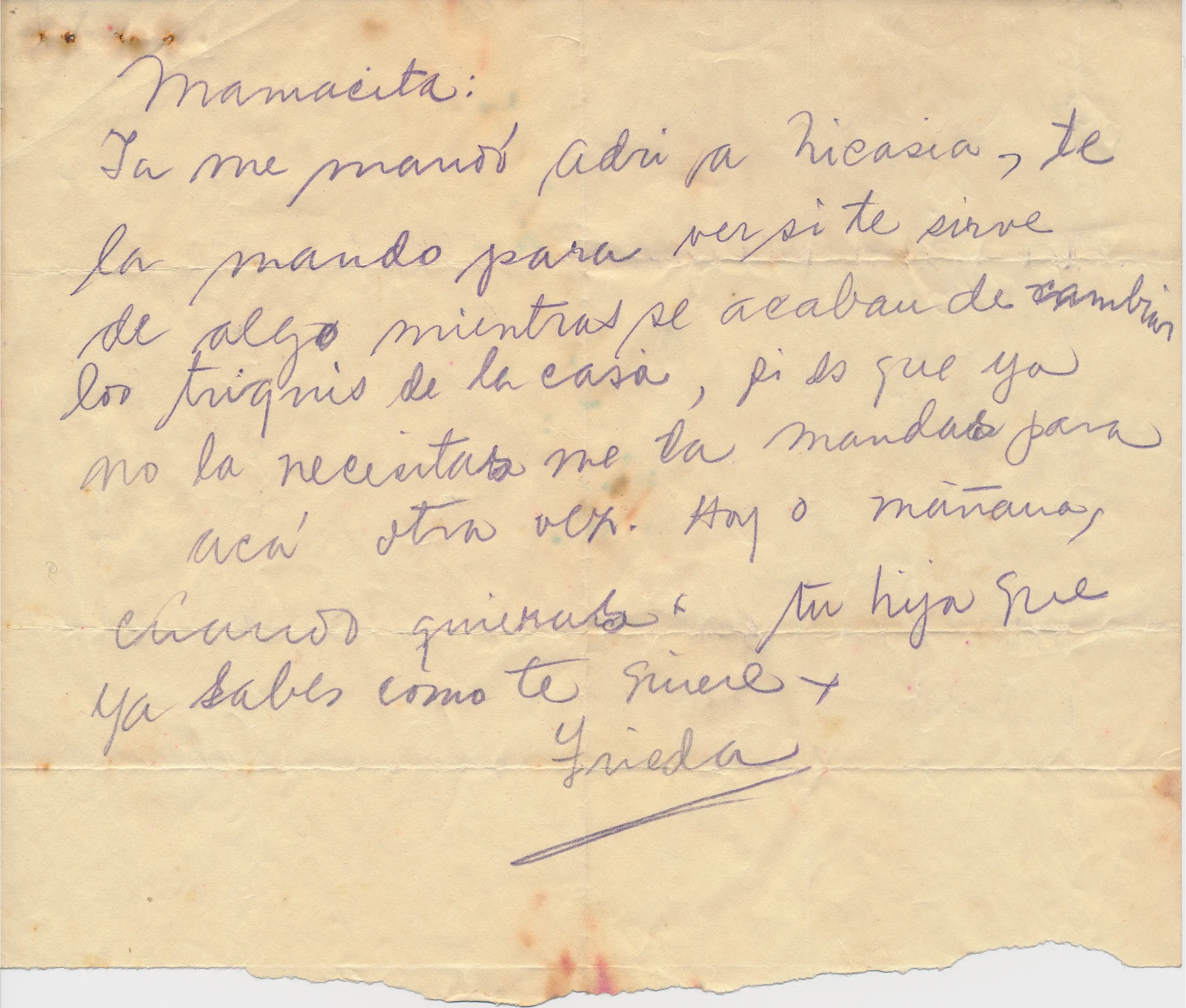 A handwritten letter by Frida Kahlo in Spanish on a piece of tan colored paper that is torn in half.