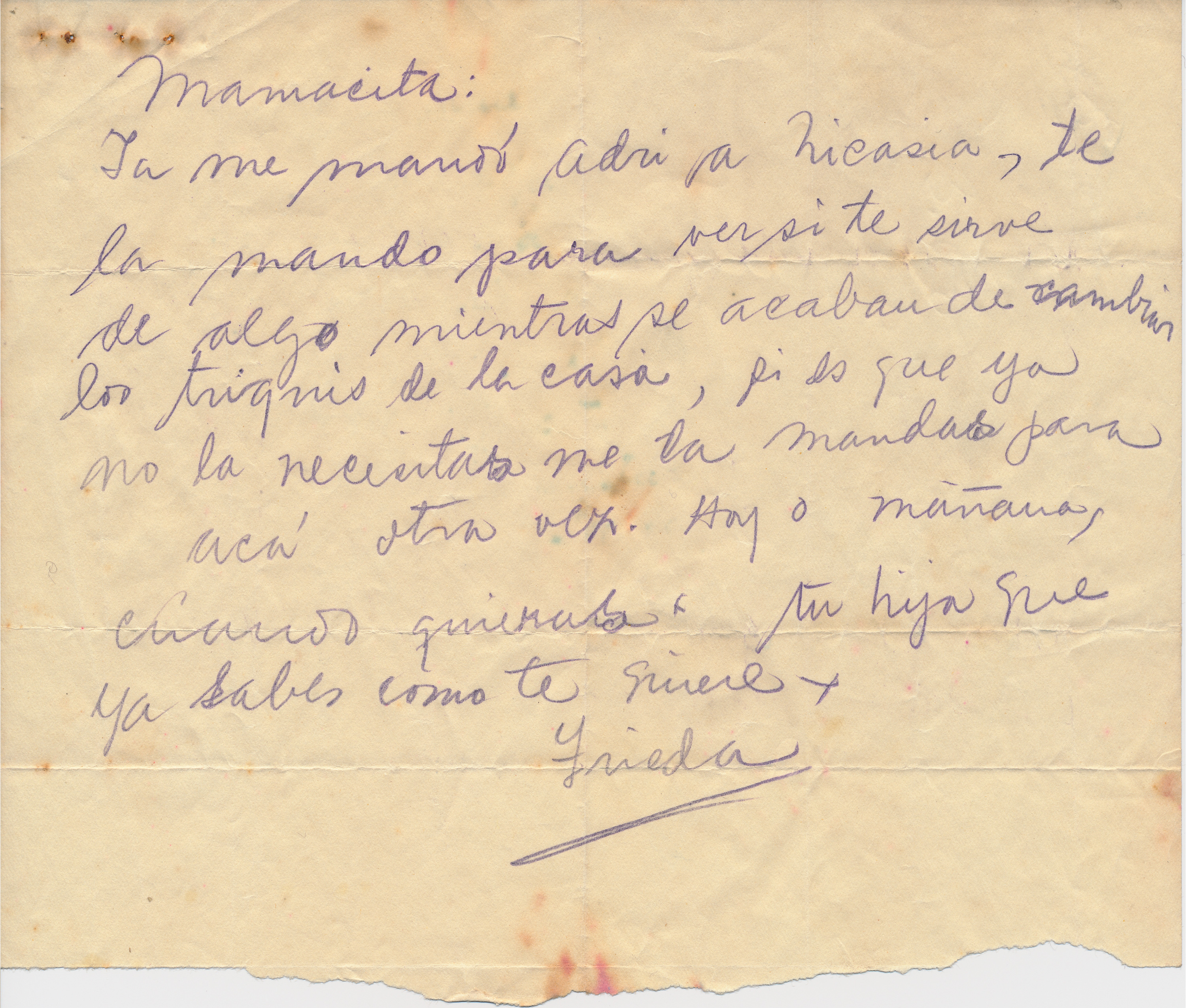 A handwritten letter by Frida Kahlo in Spanish on a piece of tan colored paper that is torn in half.