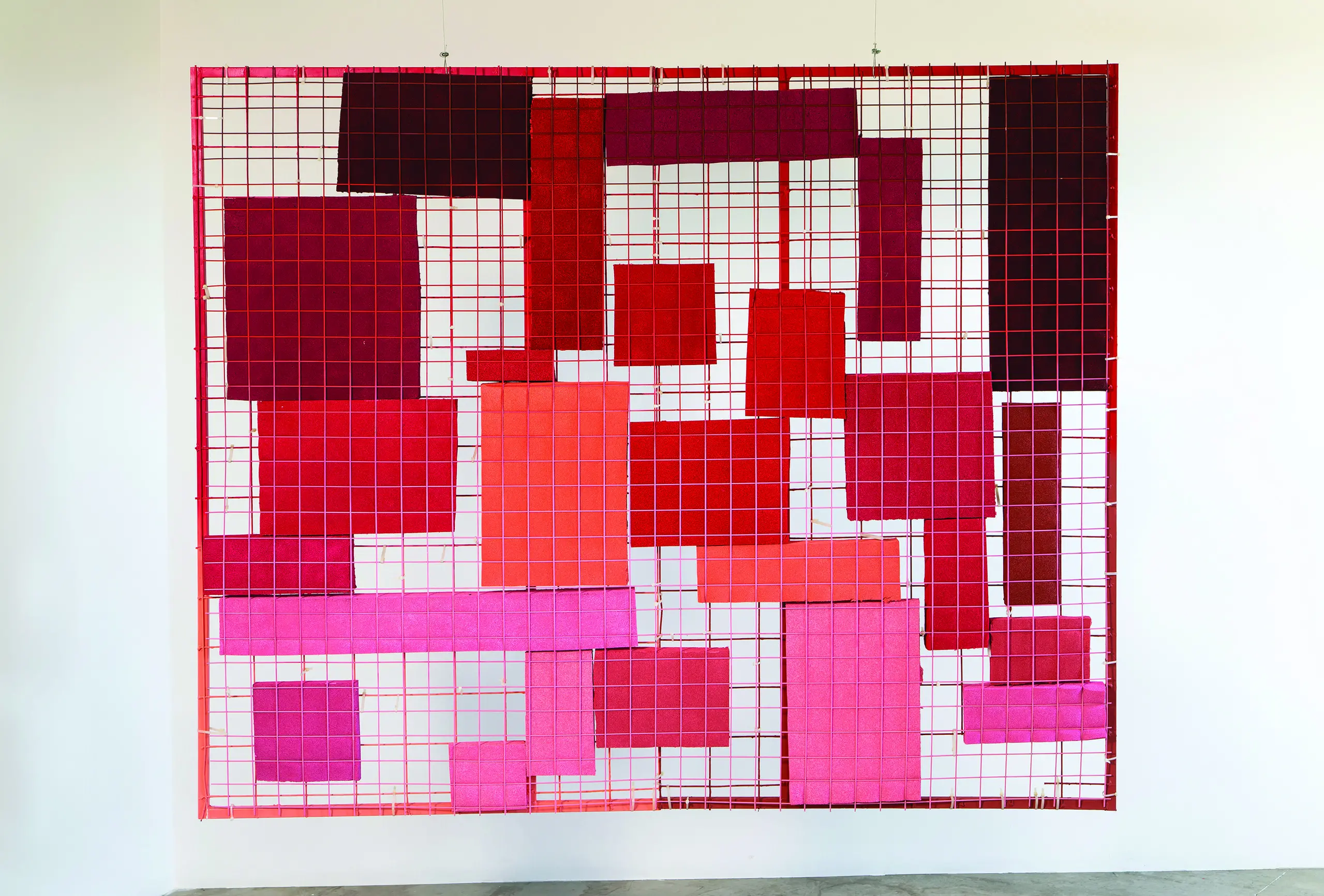 Geometric abstraction featuring red, orange, and pink rectangles sandwiched between red grates.