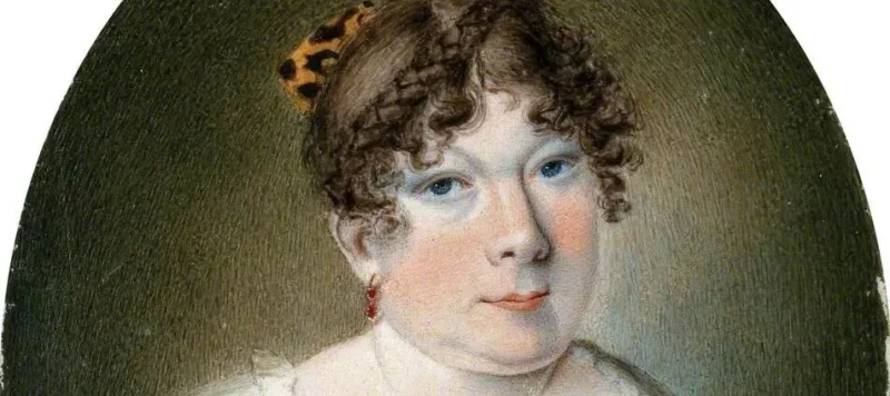 A miniature watercolor painting features a light-skinned woman with underdeveloped arms wearing a white dress with a blue ribbon tied around the bodice. Her curly brown hair is worn up in a bow. She looks at the viewer with a neutral expression.