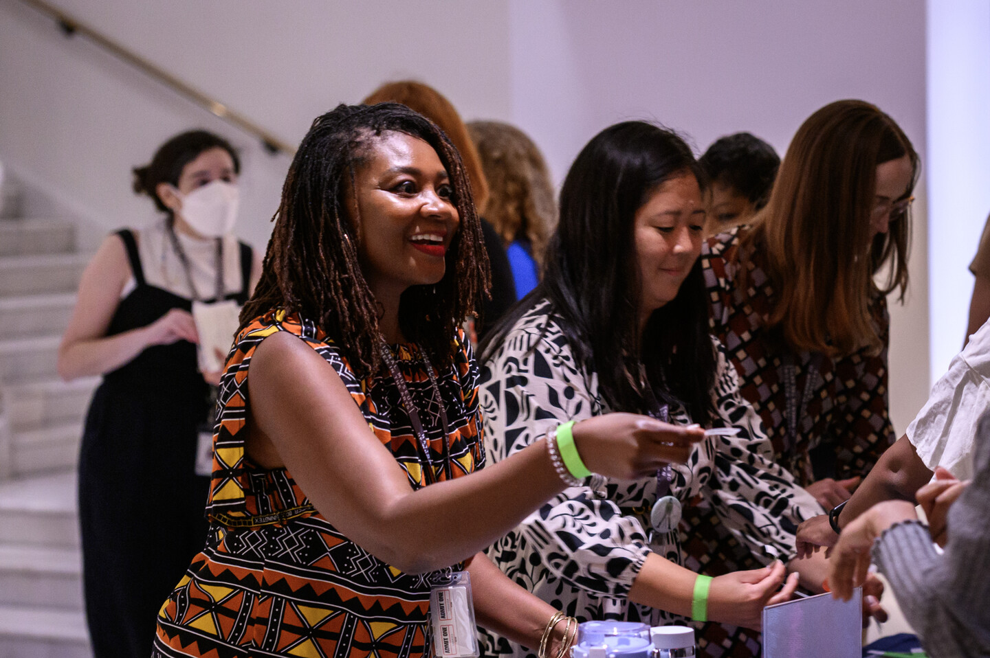 A woman hands someone paper tickets from behind a table