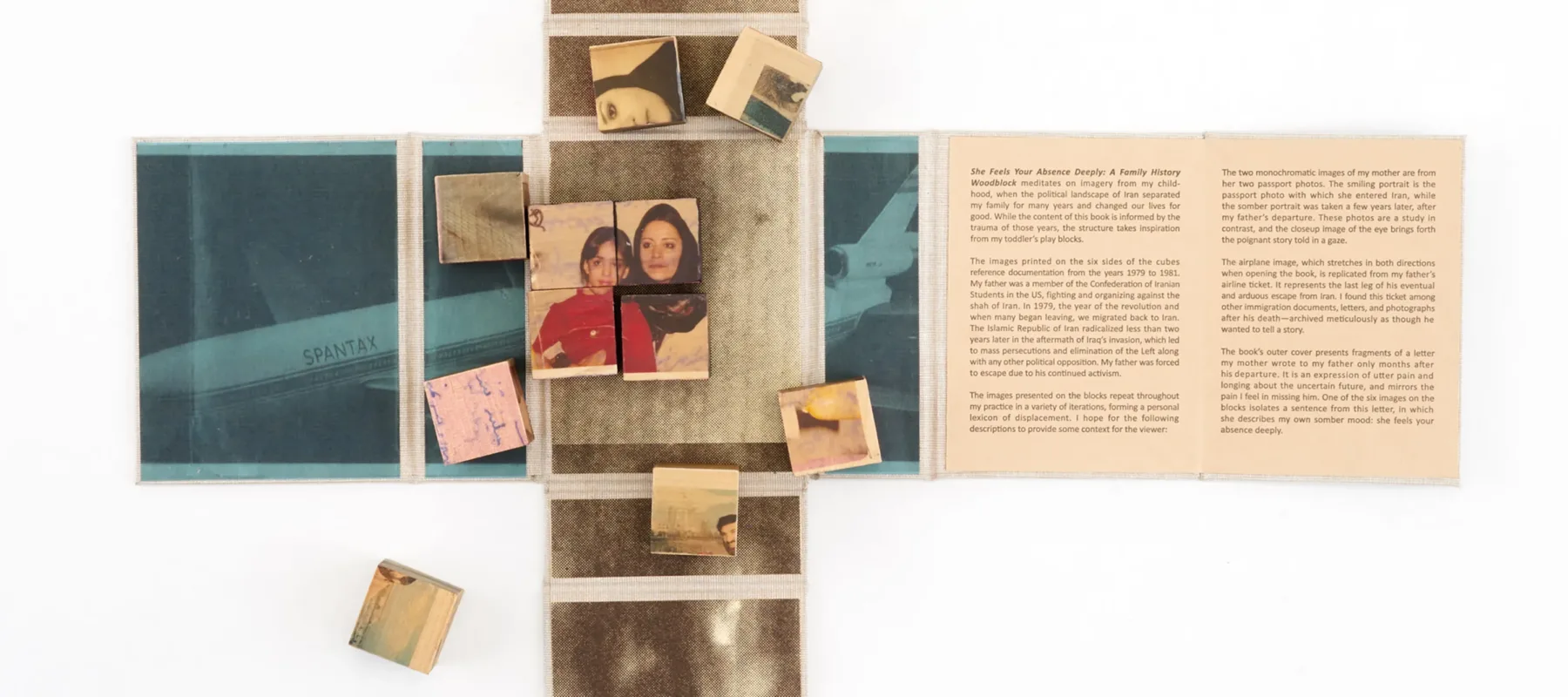 Wooden blocks with vintage photos and text are arranged on an unfolded book or map. Some blocks form a partially completed puzzle. The surrounding surface contains faded images and text panels.