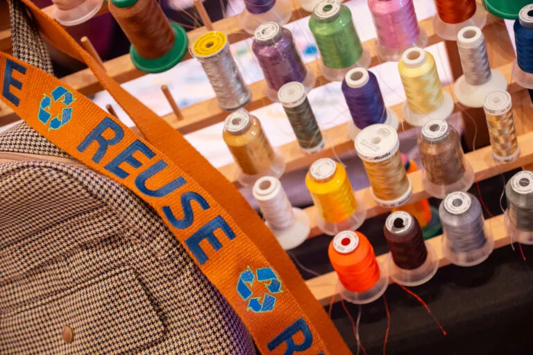 Five rows of thread in various colors, along with an orange ribbon that says 'reuse' on it.