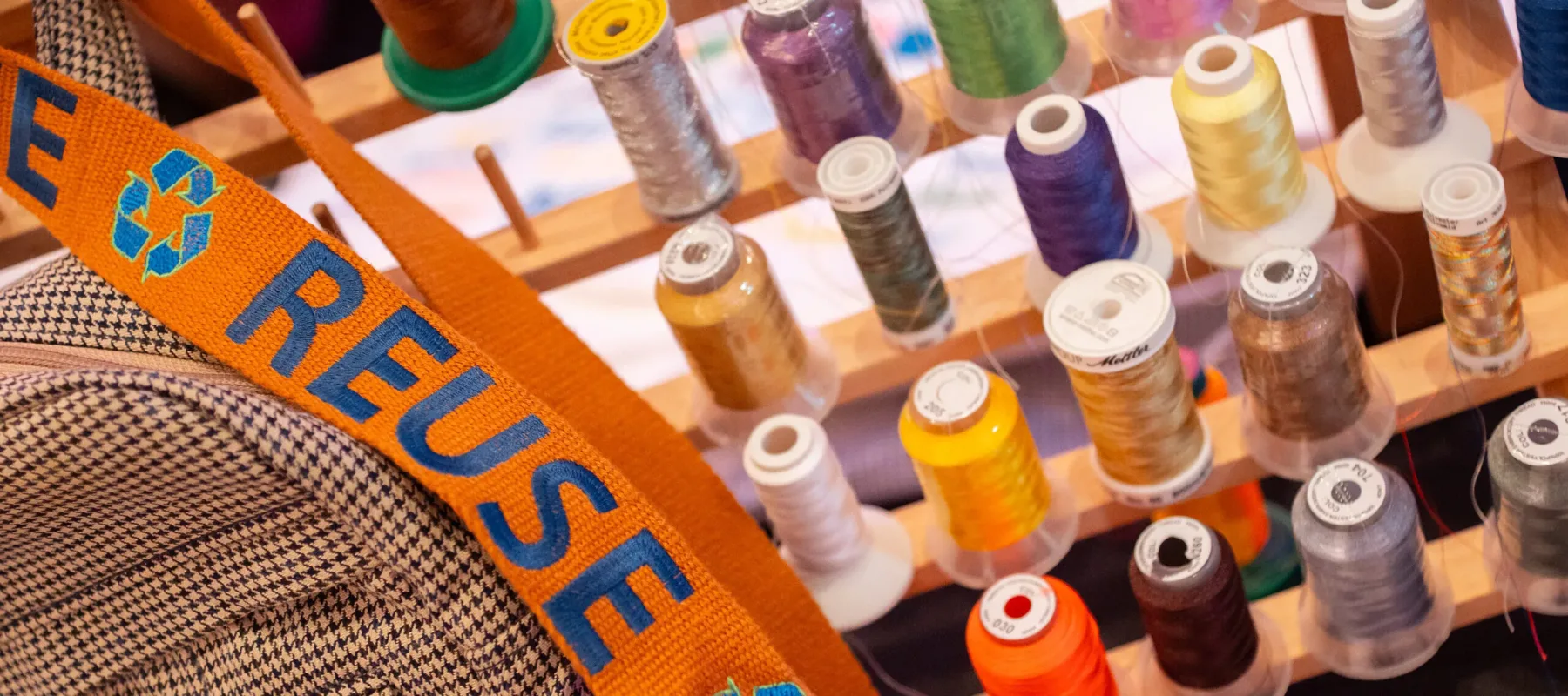 Five rows of thread in various colors, along with an orange ribbon that says 'reuse' on it.