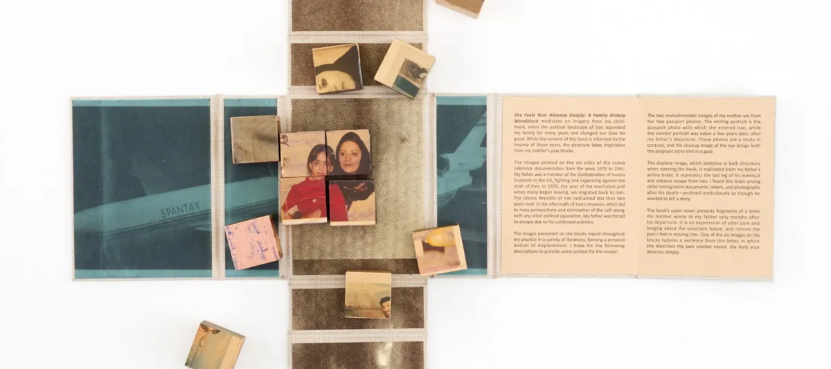 Wooden blocks with vintage photos and text are arranged on an unfolded book or map. Some blocks form a partially completed puzzle. The surrounding surface contains faded images and text panels.