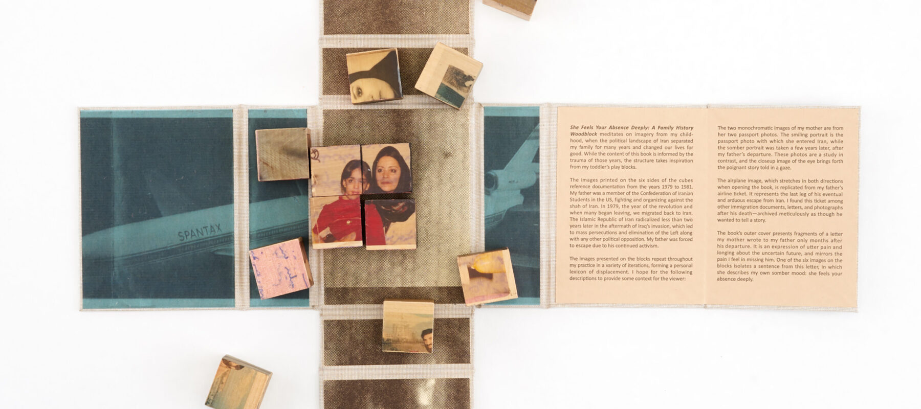 Wooden blocks with vintage photos and text are arranged on an unfolded book or map. Some blocks form a partially completed puzzle. The surrounding surface contains faded images and text panels.