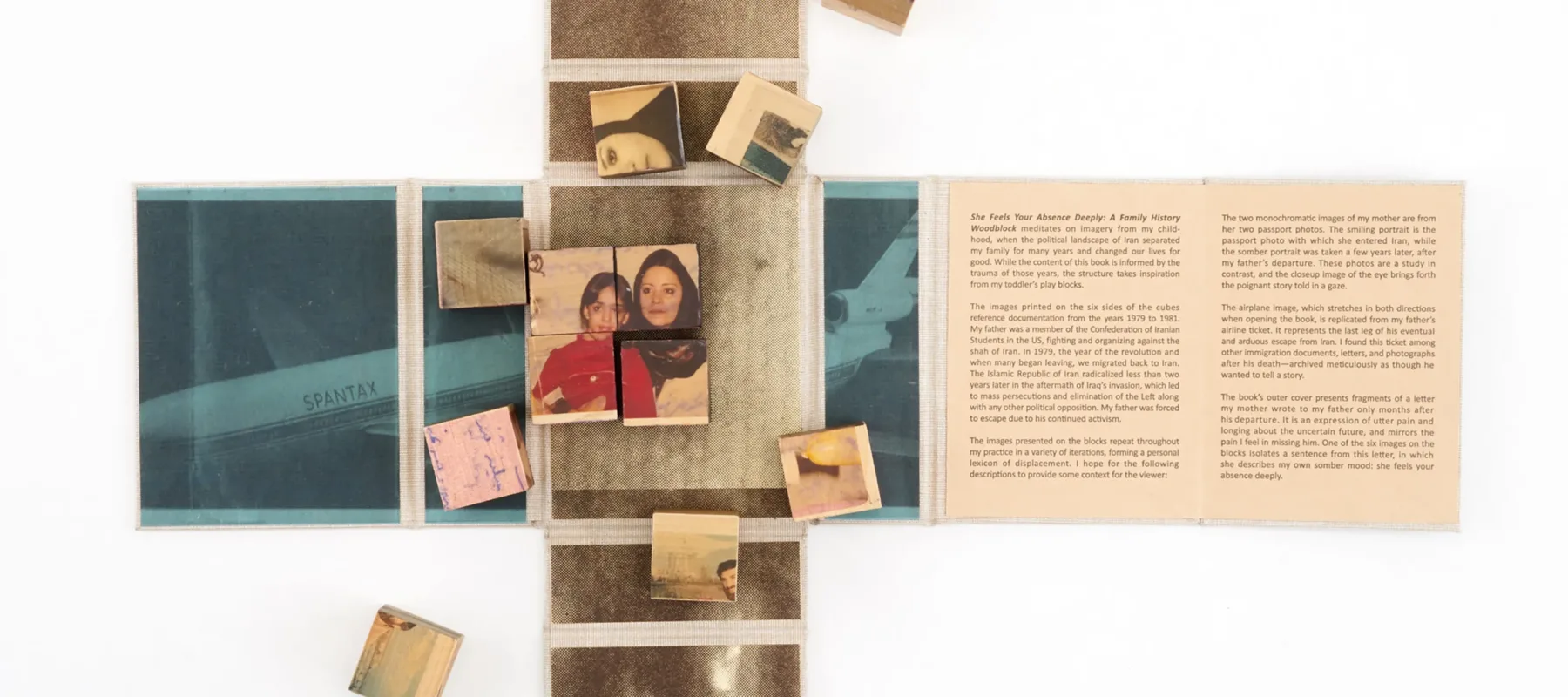 Wooden blocks with vintage photos and text are arranged on an unfolded book or map. Some blocks form a partially completed puzzle. The surrounding surface contains faded images and text panels.