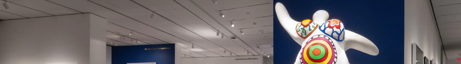 View of a gallery with works of art installed on the walls and on pedestals.
