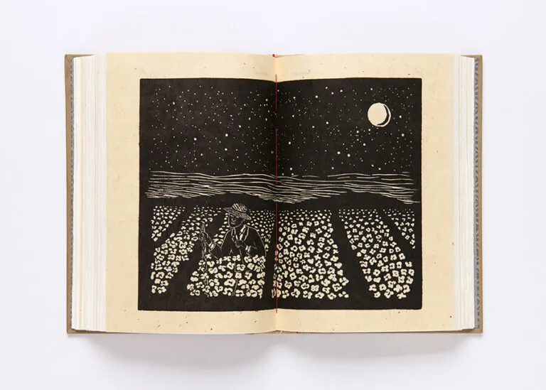 An open book on a white background displays a black and white print depicting a person picking cotton in a field with several cotton patches. The moon and stars are present in the night sky above.