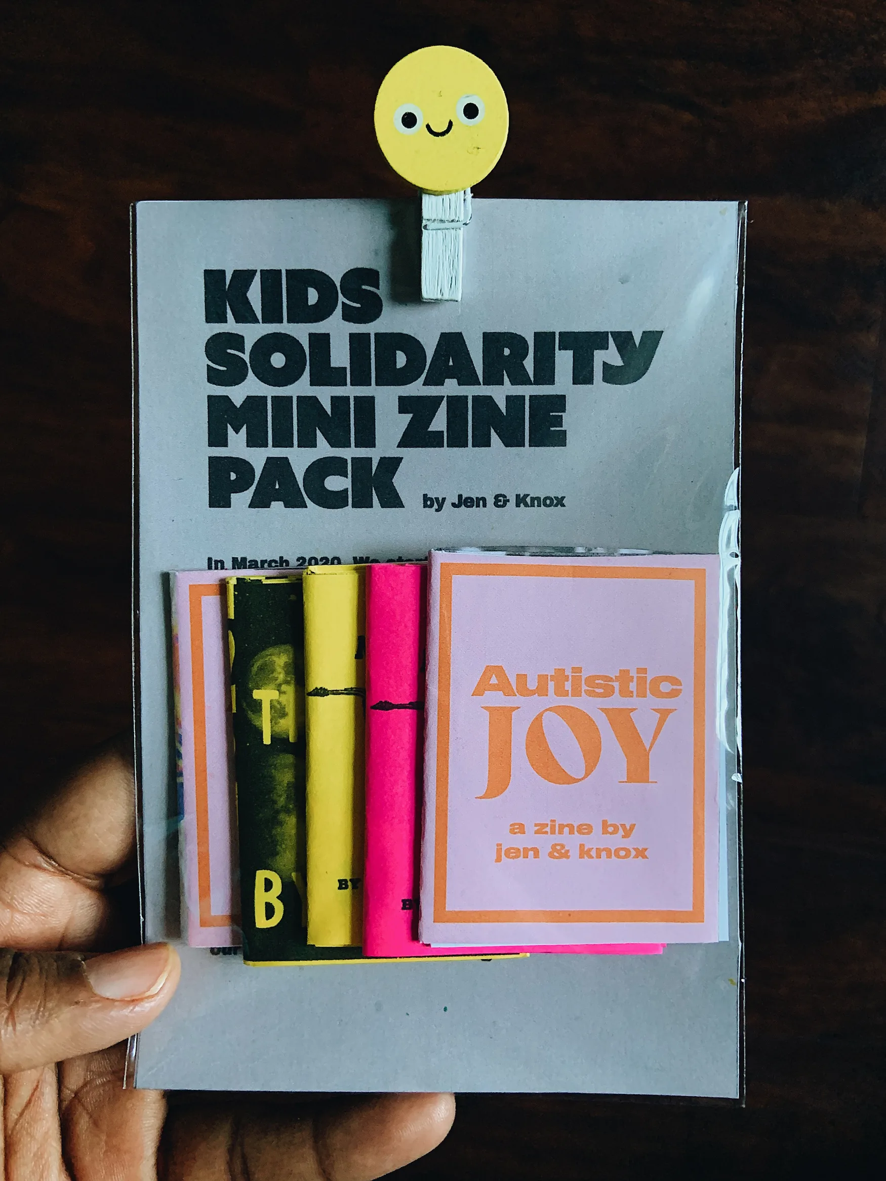 A bundle of four mini zines atop a larger printed page that reads "Kids Solidarity Mini Zine Pack."
