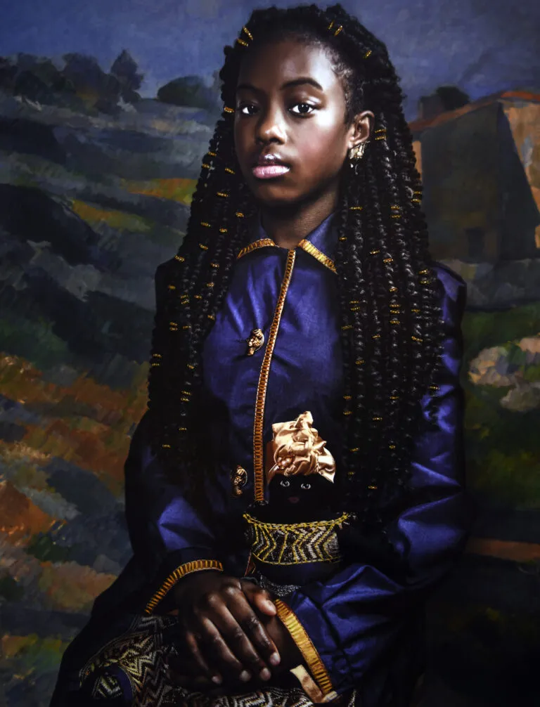 A photograph of a young Black girl. She is seated and wearing a blue dress with gold accents. She holds in her lap a doll, which is dressed in a gold dress and headwrap. The background is a landscape painting by Cezanne.