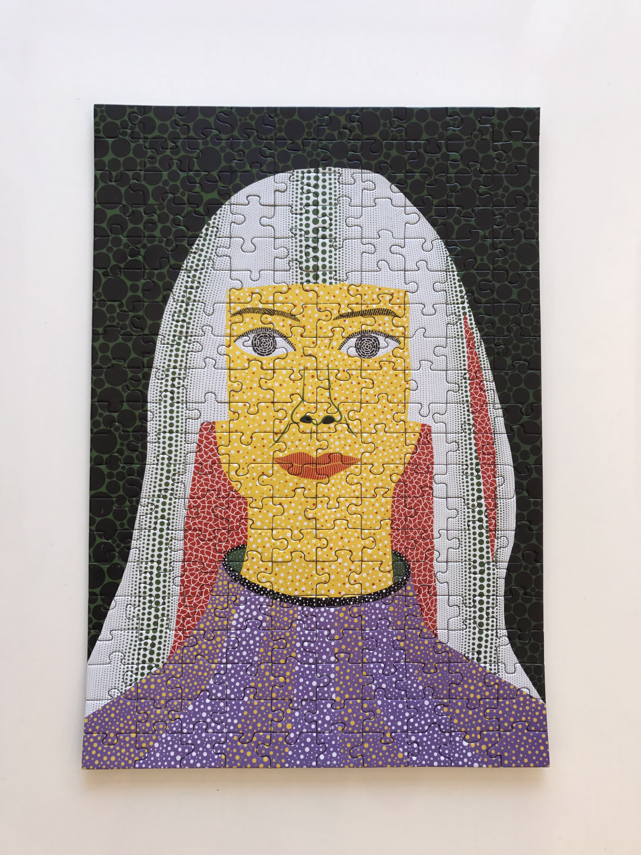 A completed jigsaw puzzle featuring a stylized portrait of a person with yellow skin, red lips, white hair, and a purple top, set against a dark, textured background.