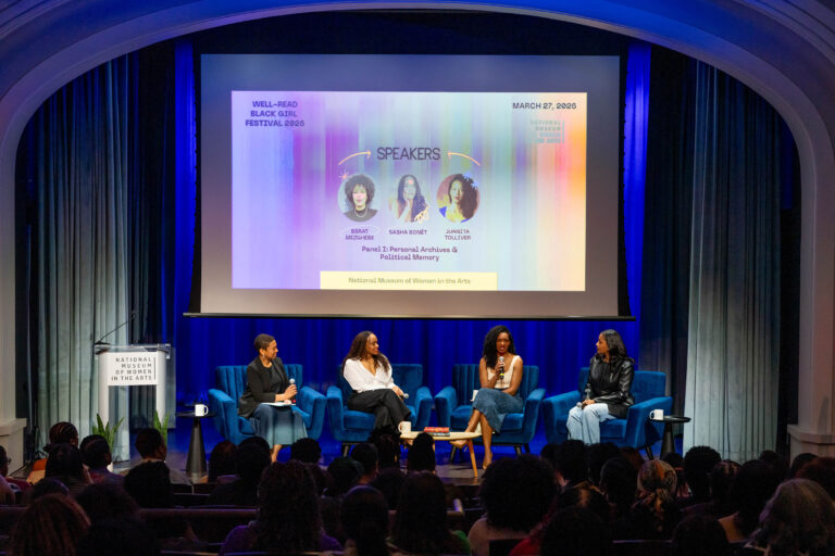Four women sit on stage discussing in front of an audience, with a projected screen behind them showing event details for the Well-Read Black Girl Festival 2025 at the National Museum of Women in the Arts.