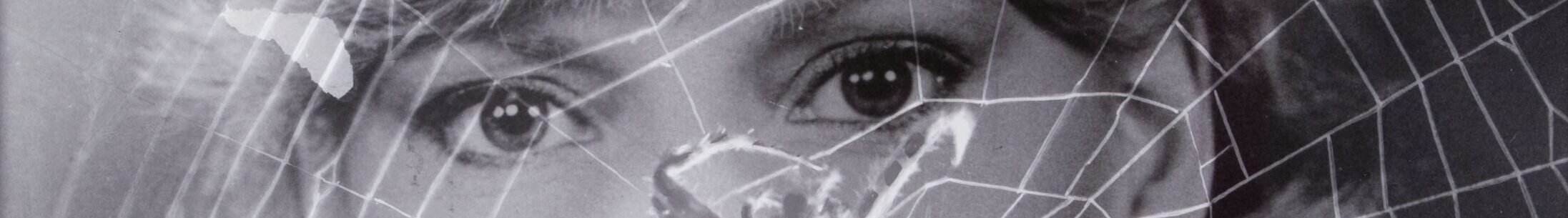 A black-and-white portrait photograph of a woman with light skin tone and light hair is overlaid with the image of a spiderweb. The web’s lines cross over her face and upper body as she gazes directly at the camera.